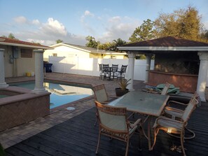 Relax and dine in style on the outdoor patio, featuring a table, wicker chairs, and a barbecue area.