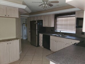 Enjoy cooking in this well-equipped kitchen with a refrigerator, dishwasher, and ample counter space.