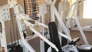 Una palestra con diverse macchine per esercizi, tra cui una pressa per le gambe e una per il petto.