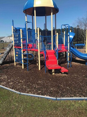 Explore the playground's multiple play areas with slides and climbing elements.
