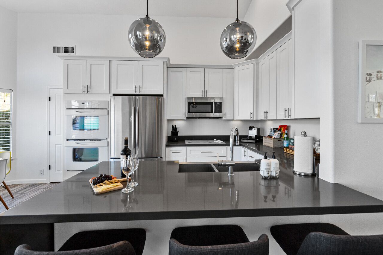 A modern kitchen with white cabinets, stainless steel appliances, and a central island with seating.