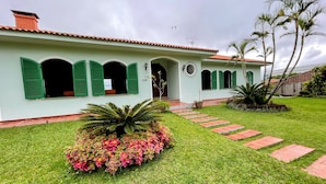 A building with a green facade, multiple arched windows, and a central entrance. - Dom Ravello (Telemaco Borba)