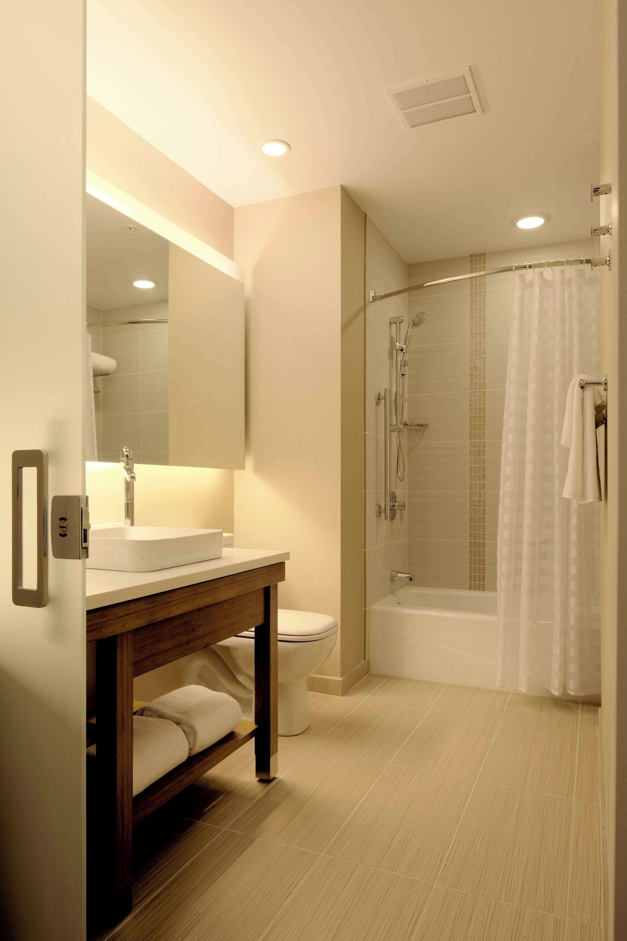 A modern bathroom with a white sink, toilet, and bathtub.
