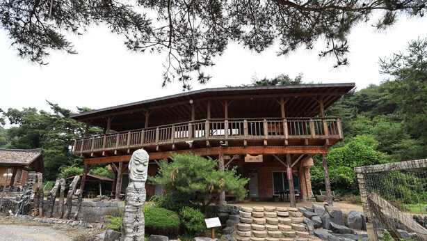 Un bâtiment de style japonais traditionnel, doté d’un balcon en bois, d’escaliers en pierre et d’une lanterne en pierre.