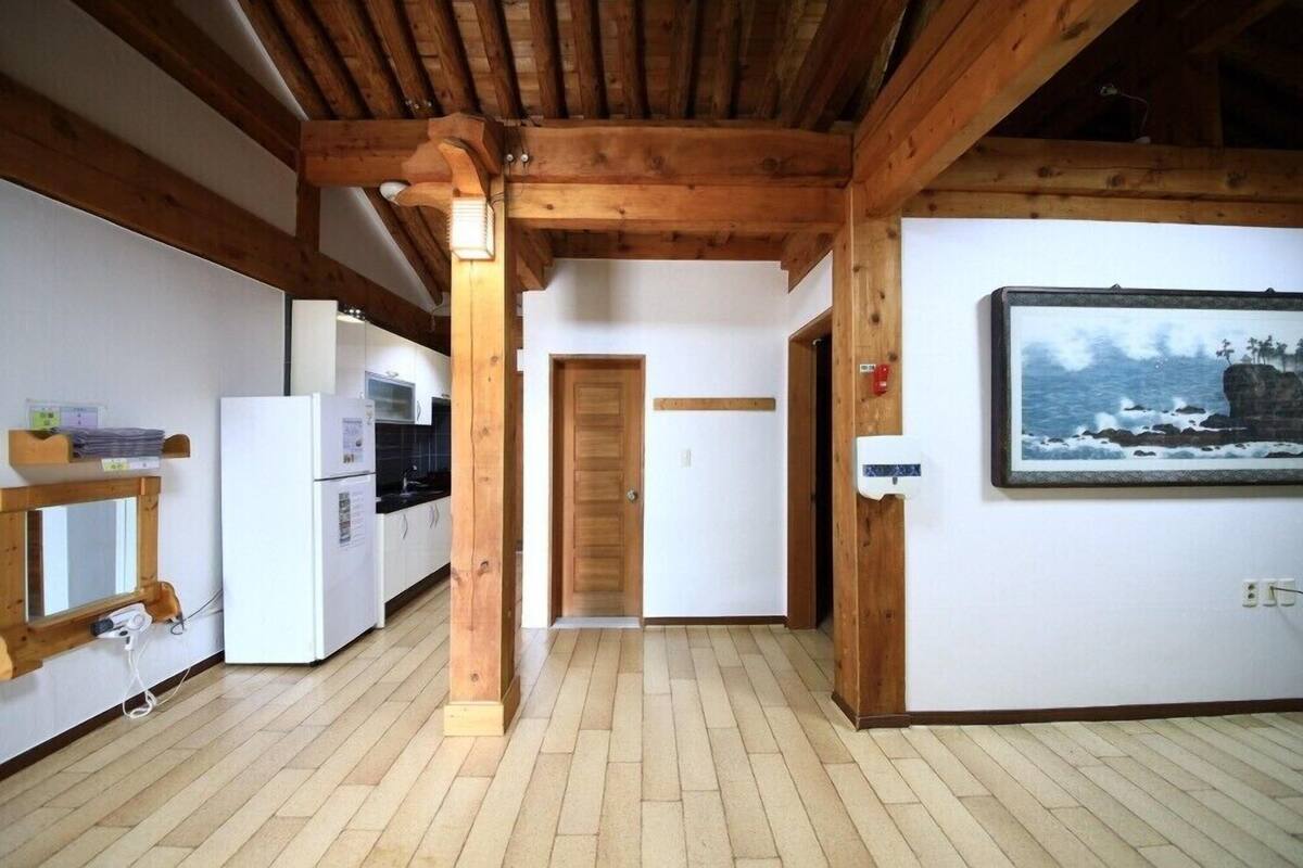 Eine Küche mit Holzbalken, einem Kühlschrank und einem Holzregal.