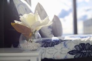 A vase with white flowers on a bedside table.