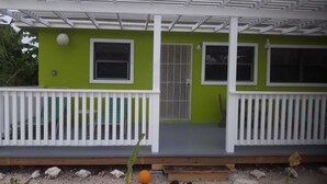 A two-story building with a green exterior and white railings. - Sagusta Gardens NCA 1 (Whitby)