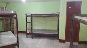 A room with bunk beds and a desk.