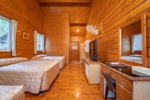 A wooden cabin with two beds, a TV, and a desk. - New Era Art Resort & Spa (Puli)