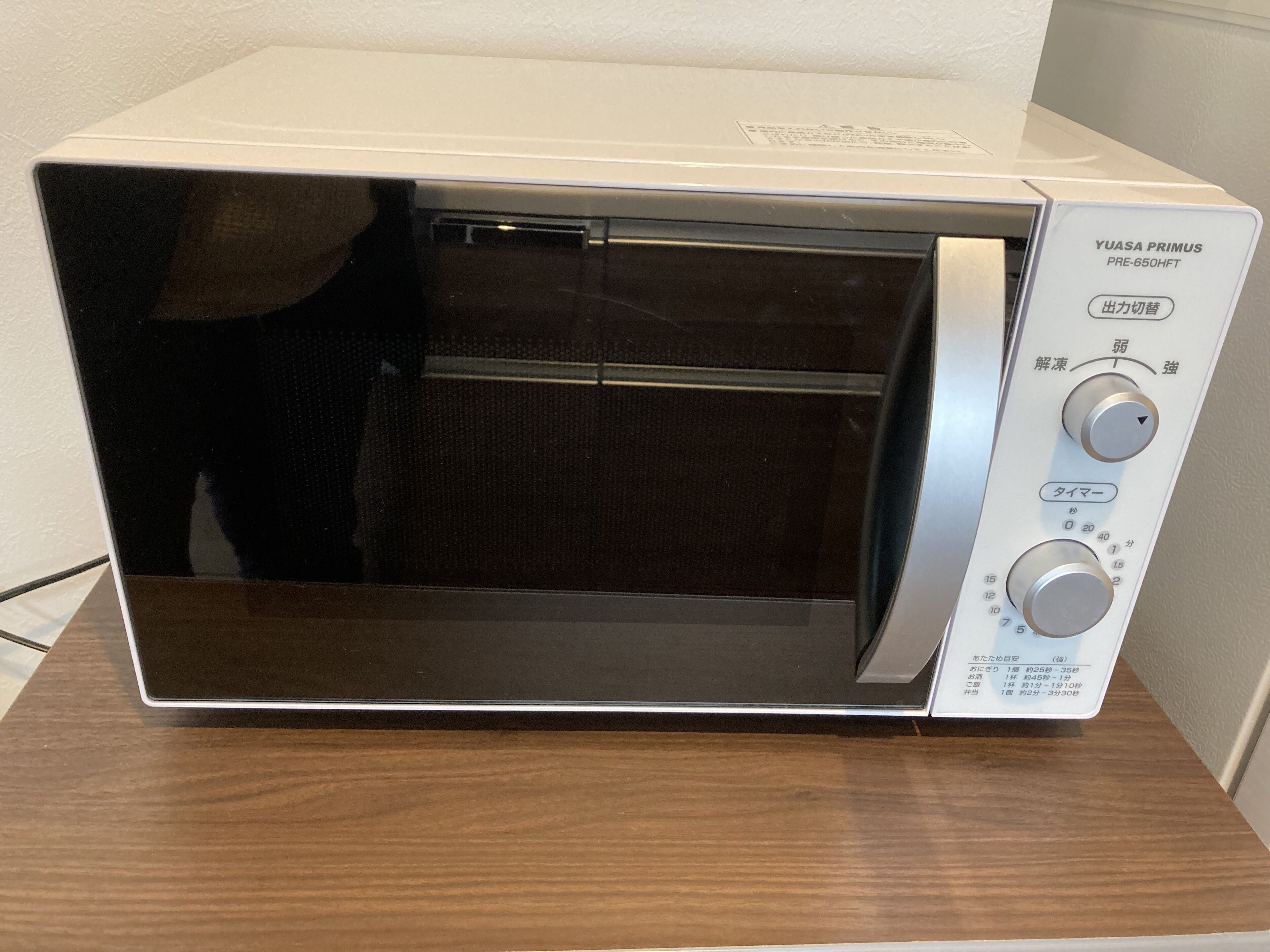 A white microwave oven with a digital display and control knobs on the right side.