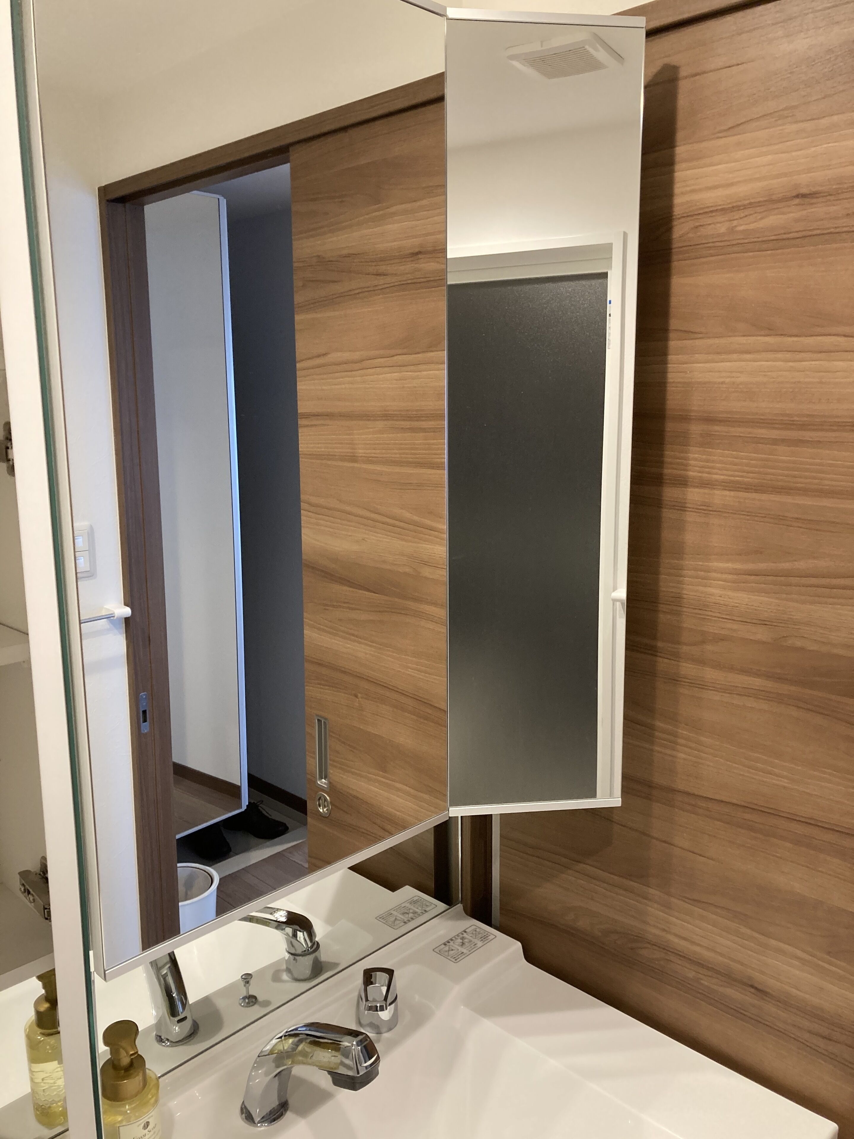 A bathroom with a white sink, chrome faucets, and a mirror.