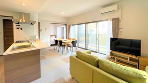 A modern hotel room with a kitchenette, a dining area, a sofa, and a TV. - A.T. Hotel Hakata (Fukuoka)