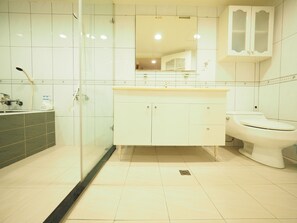 A bathroom with a glass shower enclosure, a white sink, a toilet, and a cabinet with a mirror above the sink. - Near StayReal Location (Taipei)