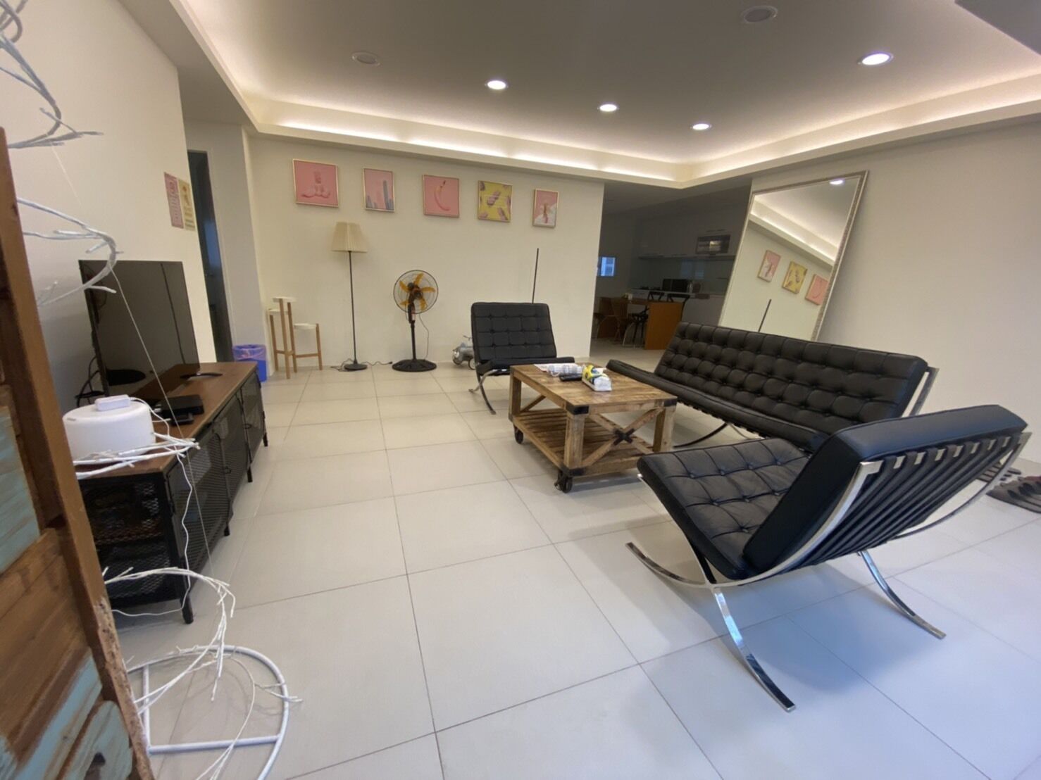 A modern living room with a sofa, chairs, a coffee table, and a TV.