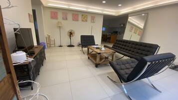 A modern living room with a sofa, chairs, a coffee table, and a TV.