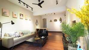 A modern living room with a sofa, coffee table, and decorative mirrors. - Near StayReal Location (Taipei)