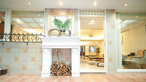 A room with a fireplace, a dining area, and a seating area with a sofa and chairs. - Near StayReal Location (Taipei)