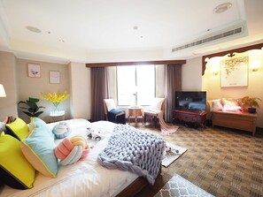 A hotel room with a bed, a TV, a desk, and a window. - Capital Family (Taipei)
