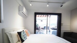 A bedroom with a bed, a window, and a view of the outside. - Yongchun MRT Station (Taipei)