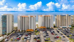 Un hôtel composé de plusieurs bâtiments, doté d’un parking et offrant une vue sur la plage.