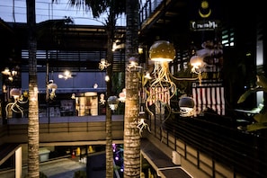 A modern indoor space with palm trees and hanging spherical lights. - 1969 Ipoh Garden (Ipoh)