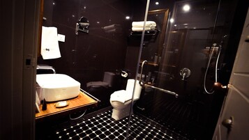 Une salle de bain moderne avec une douche à parois de verre, un lavabo blanc et des toilettes.