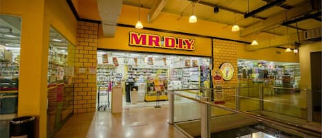 A brightly lit indoor shopping area with a prominent MRDIY store sign.