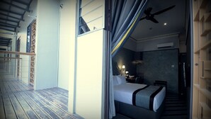 Una habitación de hotel con cama, escritorio y ventilador de techo.