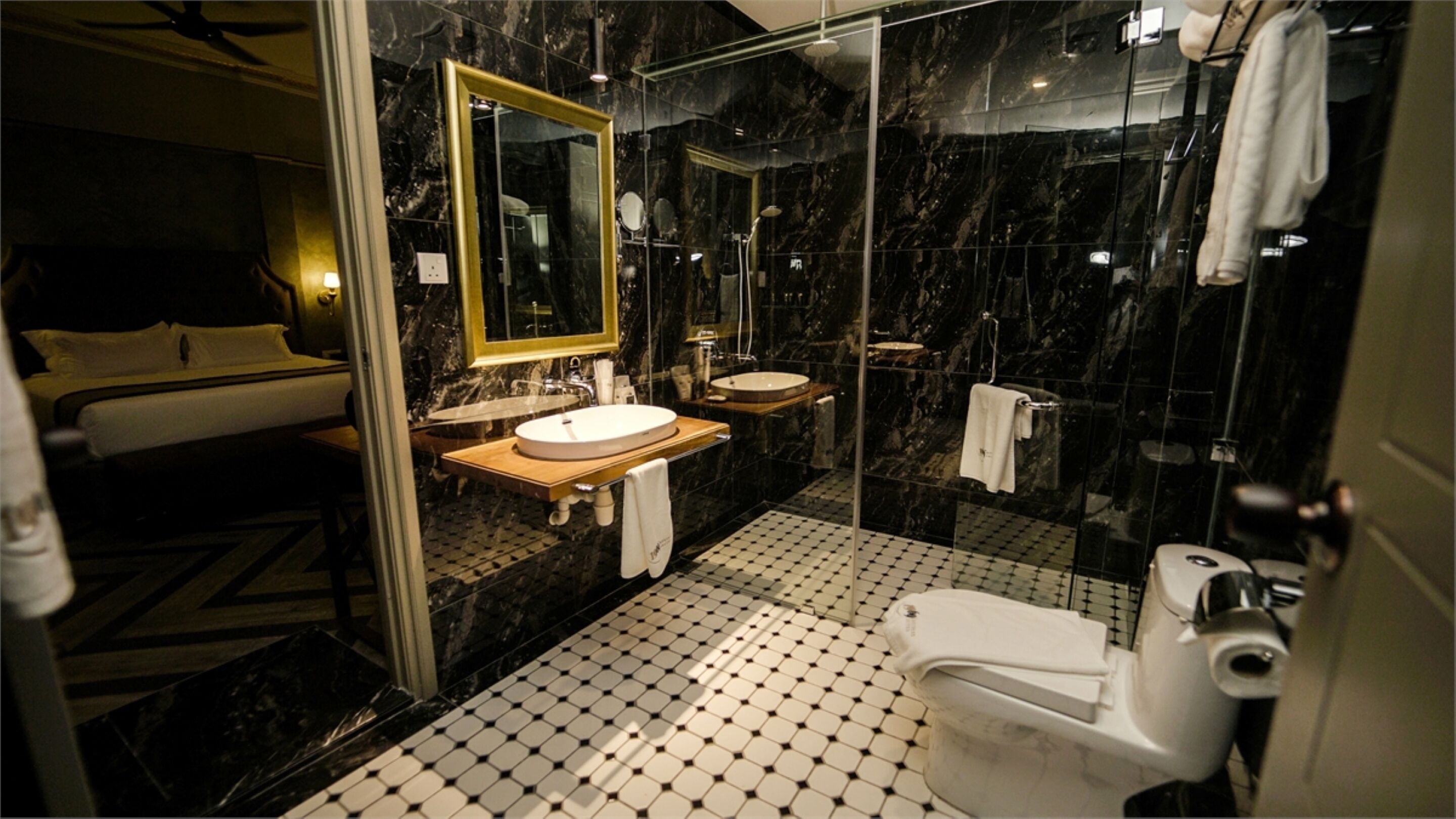 A modern bathroom with a glass-enclosed shower, a wooden vanity, a white sink, and a toilet.