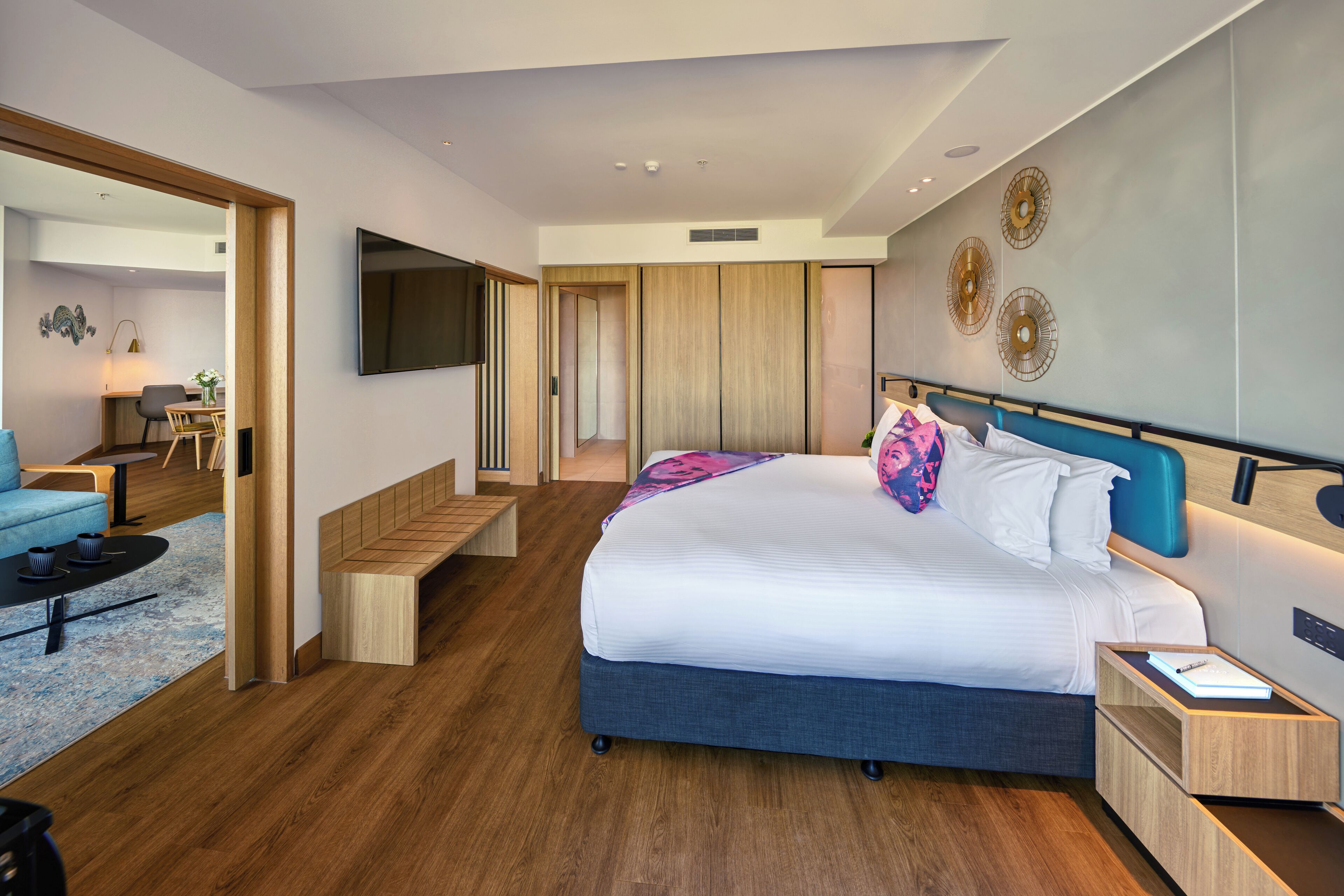 Quarto moderno com uma cama grande, uma escrivaninha e uma área de estar.