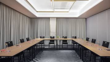 Una sala de conferencias con una larga mesa, sillas y un techo con tragaluces.