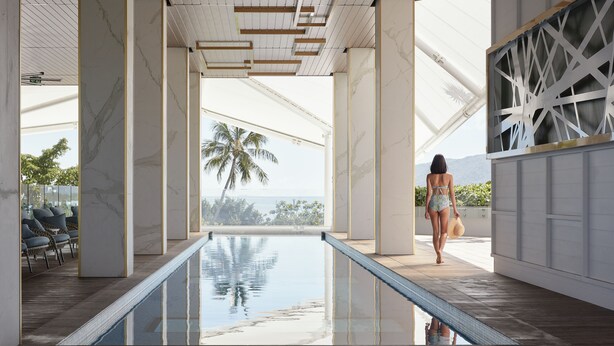 A pool area with a clear view of palm trees and mountains in the background. - Crystalbrook Flynn (Cairns)