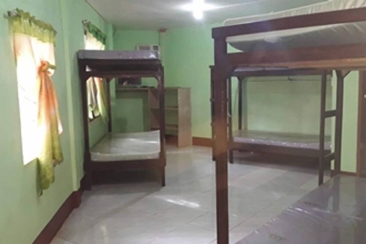 A room with bunk beds and a window with curtains.