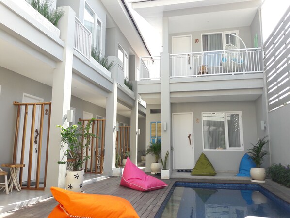 A modern apartment with a pool, balconies, and potted plants. - Mantra Gili (Gili Trawangan)