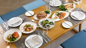 A dining table set with plates of seafood, glasses, and cutlery. - Fusion Suites Vung Tau (Ho Chi Minh City)