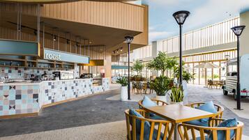An outdoor cafe area with seating and a counter labeled "roast".