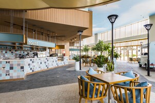 An outdoor cafe area with seating and a counter labeled "roast".