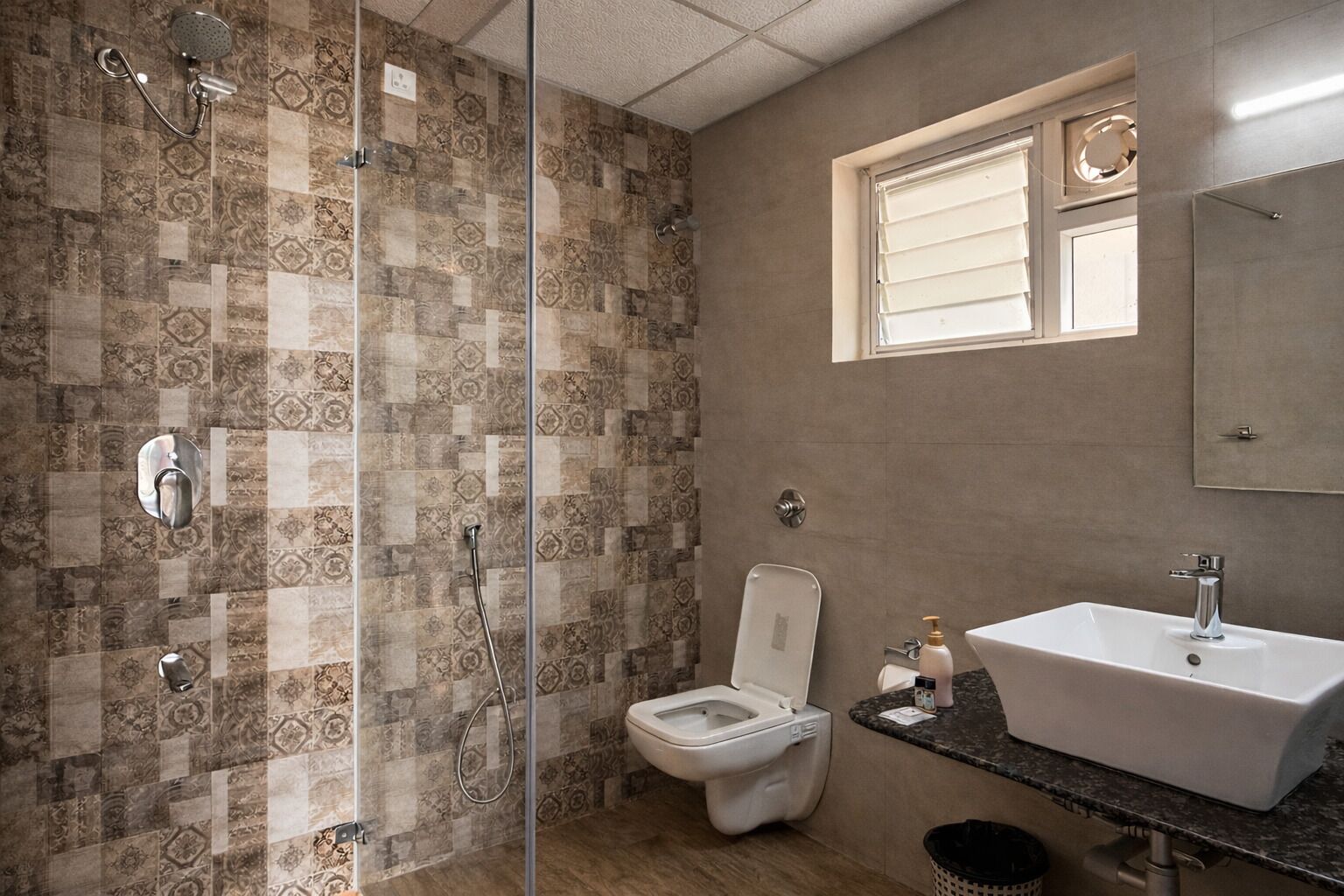 A bathroom with a shower, toilet, sink, and a window.