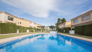 A swimming pool surrounded by modern buildings with a clear sky.