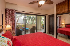 A hotel room with a bed, a balcony with wicker furniture, and a ceiling fan. - Marina Sol Condominiums (Cabo San Lucas)