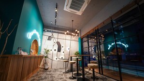 Um interior moderno com balcão de recepção, área de estar e amplas janelas.