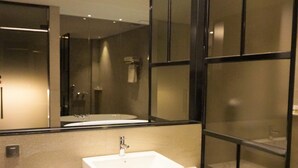 A modern bathroom with a large mirror, two sinks, and a glass partition. - Yeoubi Hotel (Changwon)