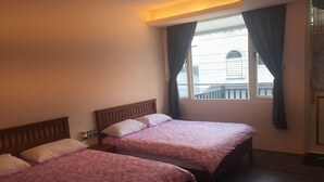 Una habitación con dos camas, una ventana con cortinas y una puerta.