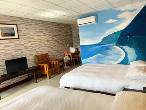 A hotel room with a large bed, a television, a wooden chair, and a painting of a coastal scene. - Golden Flower B&B (Yuli)