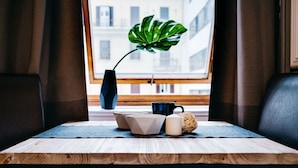 A table with a plant, a vase, and some tableware.