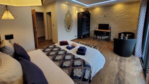 A hotel room with a bed, a desk, a television, and a wardrobe. - Les Cuves (Chaniers)