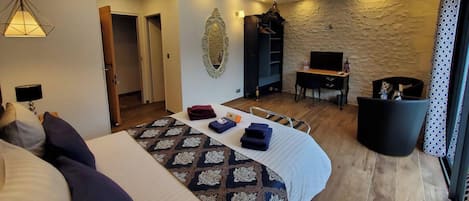 Una habitación de hotel con una cama, un escritorio, un televisor y un armario.