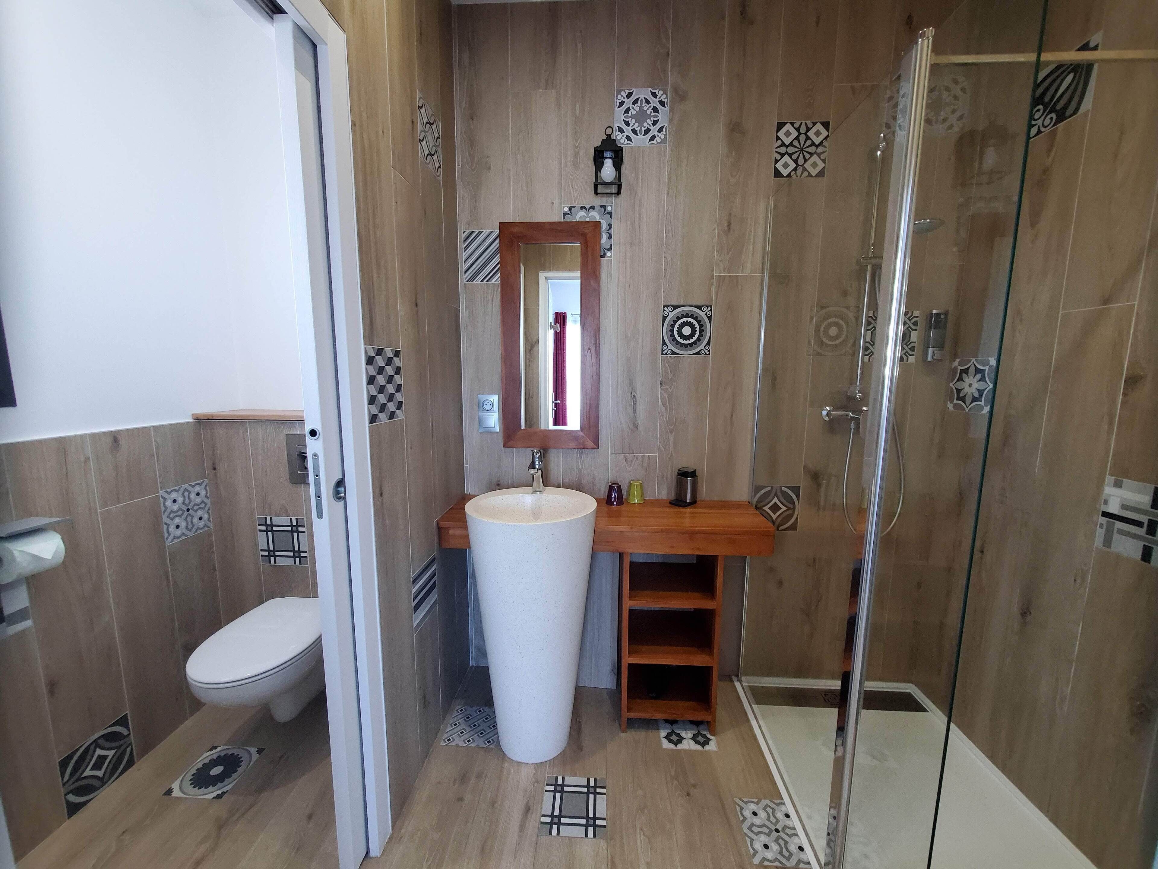 Une salle de bain avec des toilettes, un lavabo et une douche.