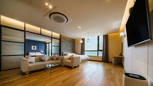 Een moderne woonkamer met een bank, een salontafel en een flatscreen televisie aan de muur.