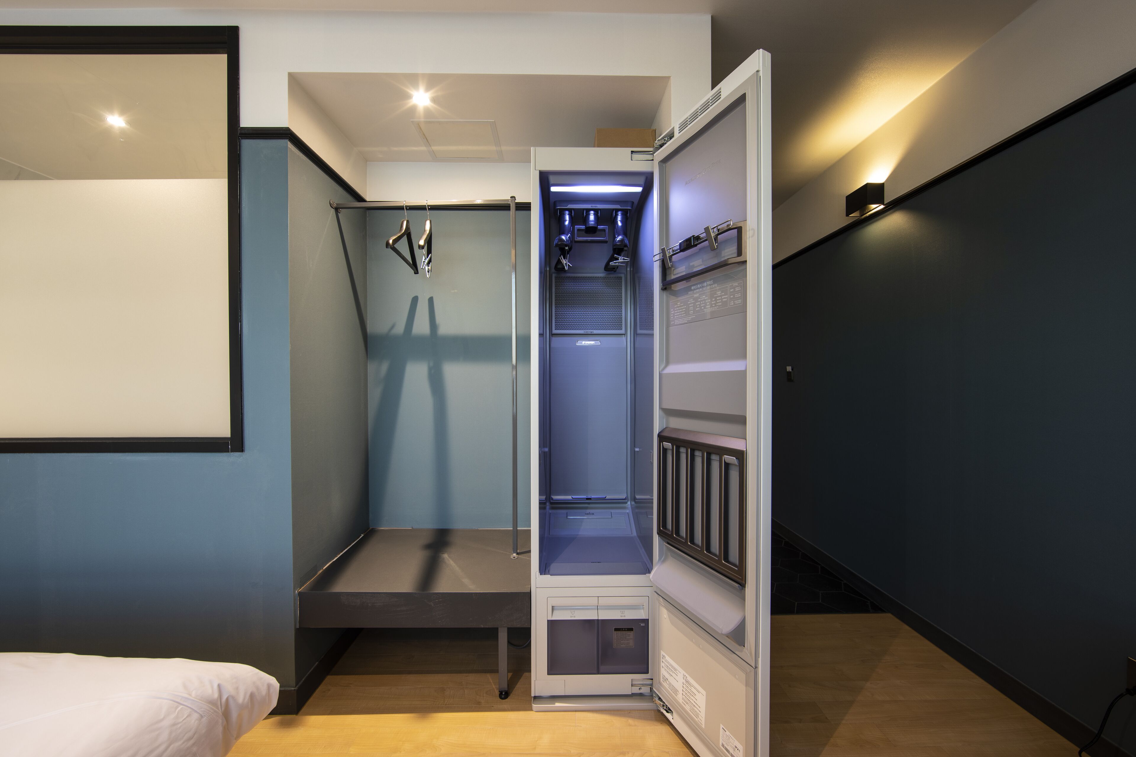 Une pièce de taille modeste comprenant un lit, une armoire intégrée et un petit coin salon.
